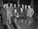 Titre original&nbsp;:  Newfoundland and Canadian Government delegation signing the agreement admitting Newfoundland to Confederation. Prime Minister Louis S. St. Laurent and Hon. A.J. Walsh shake hands following signing of agreement. 