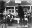Original title:  A typical religious service at Brilliant, British Columbia. On platform is Peter Petrovich Verigin. Seated is Paul Ivanovich Buirikov. 1927. 