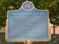 Titre original&nbsp;:  Gideon Tiffany 1774-1854 - from OntarioPlaques.com. Photo by Alan L Brown, 2004.

Plaque text: A native of New Hampshire who had come to Niagara in 1794, Tiffany was appointed King's Printer and published the official "Upper Canada Gazette" until 1797. He was not a Loyalist and the government, concerned by his American background, forced his resignation. In 1799 he and his brother Sylvester founded at Niagara this province's first independent newspaper, the "Canada Constellation". When it failed in 1800, Gideon moved to Delaware where, with Moses Brigham and another brother Dr. Oliver Tiffany of Ancaster, he purchased a large tract of land, including the site of the present village, from Ebenezer Allan and others. Active in township affairs, he remained here for the rest of his life. 